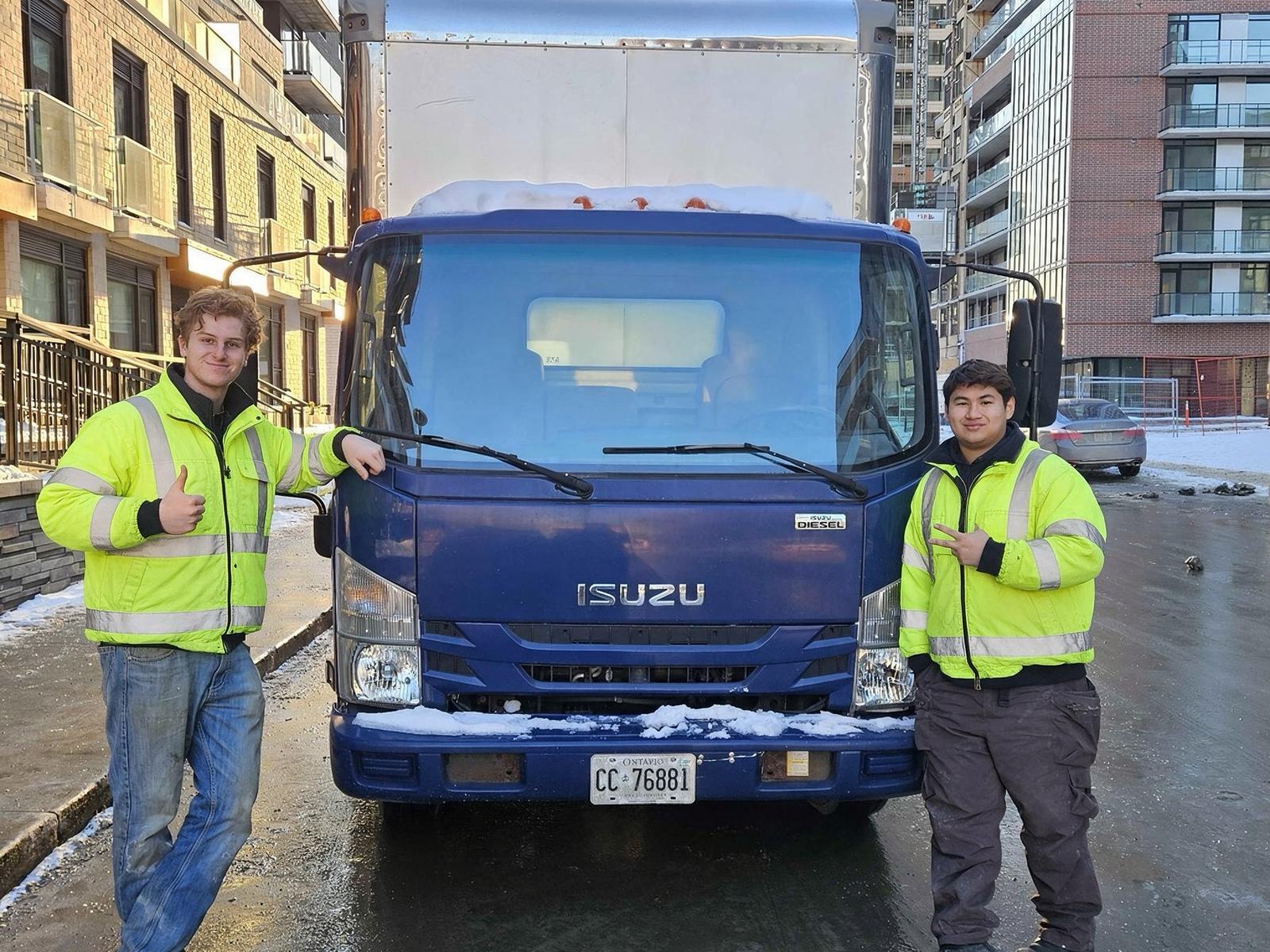 Wastely crew in high-visibility jackets in front of the company truck